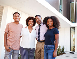 Family standing in front of their house. Link to Gifts of Real Estate